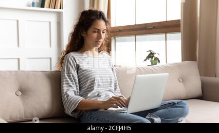 Woman relaxing on couch using laptop search information on internet Stock Photo