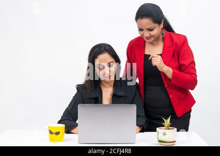 Two professional Indian women working on computer, work from home, Corporate employees holding video meeting with client, Stock Photo