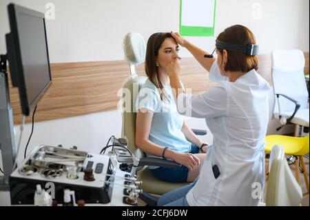Female ent doctor and patient in office, exam Stock Photo