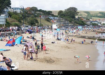 Tourists enjoy a summer day at the beach at Swanage, Dorset, UK Stock Photo