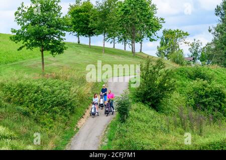 A group of golfers on a golf course in the Allgäu, playing golf in a beautiful landscape. Stock Photo