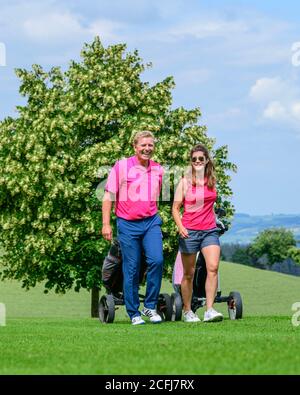 Couple on the way on golf course Stock Photo