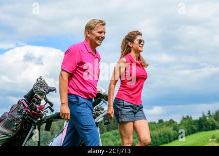 Couple on the way on golf course Stock Photo