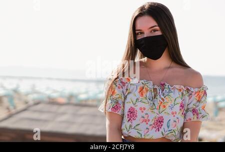 Teeneger focusing in the camera with black face mask on Stock Photo