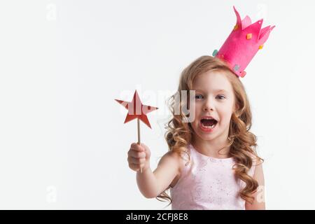 Beautiful little candy princess girl in crown holding star shaped magic wand isolated on white Stock Photo