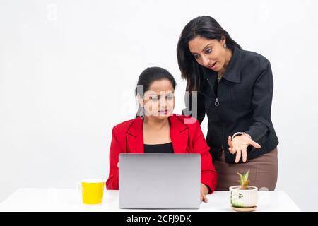 Two professional Indian women working on computer, work from home, Corporate employees holding video meeting with client, Stock Photo