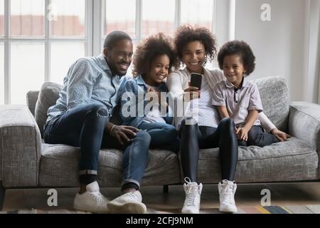 Happy african american family posing for selfie photo on cellphone.