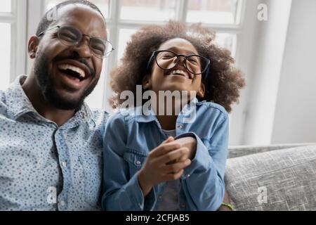 Overjoyed african american family in eyeglasses laughing at funny joke. Stock Photo