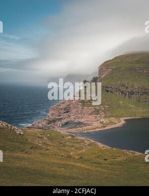 A rocky cliff on the blue ocean during a sunny day Stock Photo - Alamy