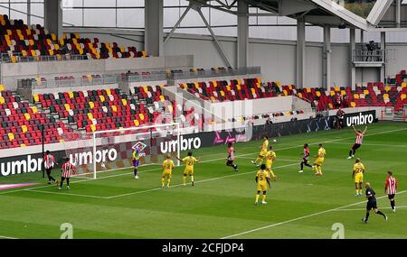 Brentford's Ethan Pinnock (no.5 left) scores his side's first goal of the game during the Carabao Cup first round match at Brentford Community Stadium, Brentford. Stock Photo