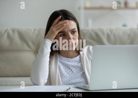 Frustrated millennial woman thinking of financial troubles. Stock Photo