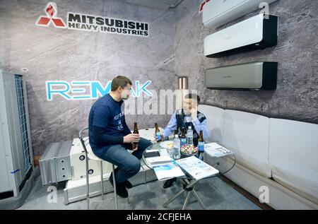 Businessmen having lunch and communicating at the shop, air conditioners placed on stands. January 12, 2020. Kiev, Ukraine Stock Photo