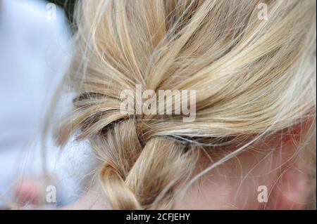 Closeup of a simple braided blonde hair under the lights with a blurry background Stock Photo