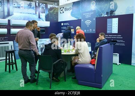 Businessmen having lunch and communicating at the shop, air conditioners placed on stands. January 12, 2020. Kiev, Ukraine Stock Photo