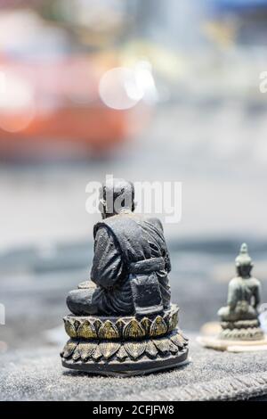 Small religious figurines on the dashboard of a moving car. Figurine of a Buddhist monk in the interior of a car, Thailand. Stock Photo