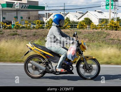 AYUTTHAYA, THAILAND, JUN 03 2020, A driver rides a motorcycle on the road. Stock Photo