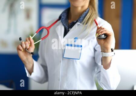 Medical officer in white coat holds stethoscope. Stock Photo