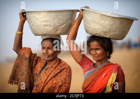 Market women wait for fish on the beach near the traditional fishing colony in Puri, Odisha, India Stock Photo