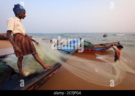 Fisherman on the beach near the traditional fishing colony in Puri, Odisha, India Stock Photo