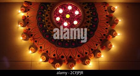Beautiful clay lamp lit around a rangoli during Festival of Lights, Diwali in India Stock Photo