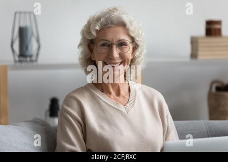 Head shot portrait smiling mature woman wearing glasses at home Stock Photo