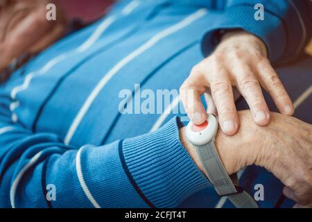 Senior man fallen pressing red button on emergency call device Stock Photo
