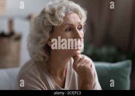 Close up thoughtful middle aged woman looking to aside Stock Photo