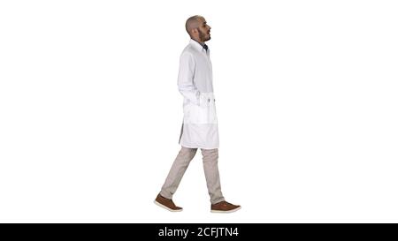 Doctor walking with hands in pockets on white background. Stock Photo
