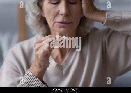 Close up unhappy sick mature woman suffering from headache Stock Photo