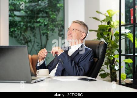Dreamy senior businessman Stock Photo