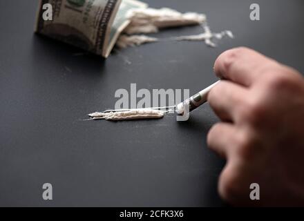 White powder as drug with money on black surface, concept picture Stock Photo