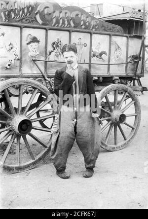 The Grand Circus, clown beside a wagon .
