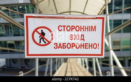 Warning sign No unauthorized entry written in red text in Ukrainian on a white rectangular table. The sign prohibits the passage of strangers Stock Photo