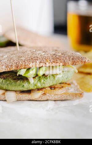 Closeup of freshly prepared sandwich with vegetable cutlet placed on table in cafe for lunch Stock Photo