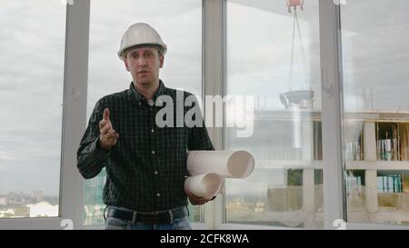 Medium shot.Mature engineer talking to camera explaining something. Professional shot in 4K resolution. 025. You can use it e.g. in your commercial vi Stock Photo