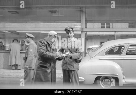 Italian customs official checking papers at the border crossing from Switzerland into Italy, October, 1951 Stock Photo