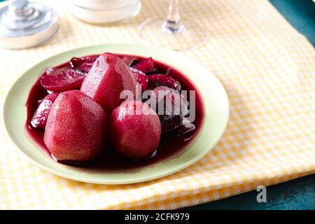 From above of tasty red wine poached pears in plate placed on table in restaurant Stock Photo