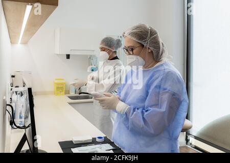 Female medical workers with protective face masks while preparing for medical procedure in hospital Stock Photo