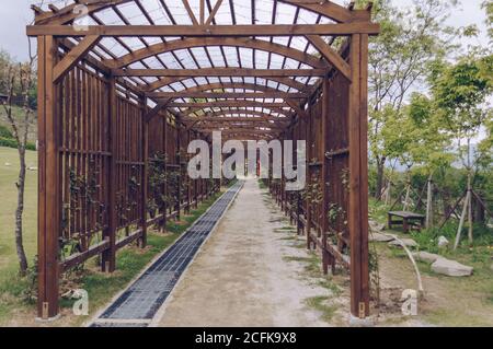 Pocheon, South Korea – 10 May, 2017: wooden passage decorated with lights and climbing roses at Pocheon Art Valley Stock Photo