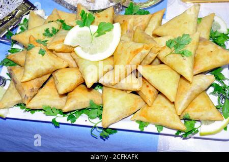 Fresh Indian Samosa with green chilli and onion slices. Stock Photo