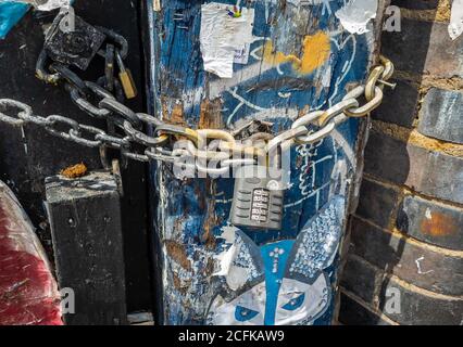 A chain and combination padlock on a old wooden gate and post. Stock Photo