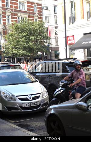 Scooter edging backwards into traffic congestion in London England Stock Photo