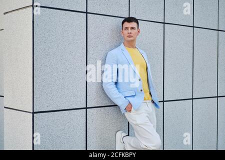 Young man on the street leaning on wall and looking away Stock Photo