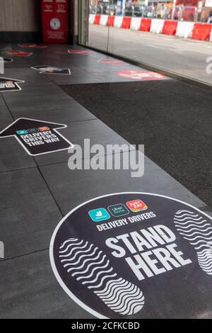 Social distancing marking on floor of a branch of KFC indicating the safe distance to keep apart while inside the restaurant. Stock Photo