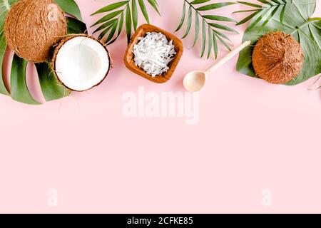 Pattern with coconuts and tropical palm leaves on pink background. Tropical abstract background. Flat lay, top view. Stock Photo