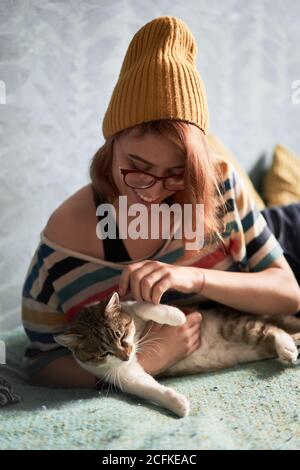 girl stroking her adorable cat at home Stock Photo