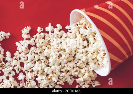 Cup with popcorn on red color background Stock Photo