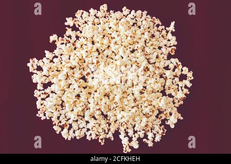 Spilled popcorn on a purple background, cinema, movies and entertainment concept Stock Photo
