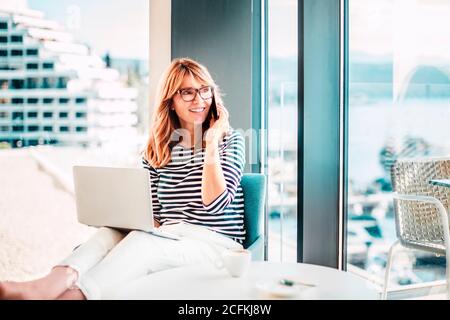 Portrait shot of confident businesswoman making a business call while sitting on chair and working from home. Home office. Stock Photo