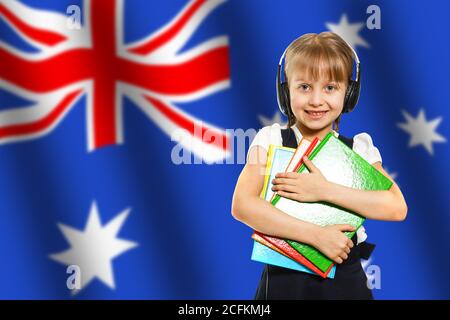 Australia concept with little girl student with book on the Australian flag background Stock Photo